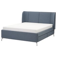 a bed with a blue headboard and white sheets on it's bottom half