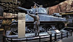 a man standing next to a tank on display