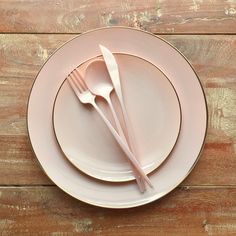 a white plate topped with two silverware next to a fork and knife on top of a wooden table