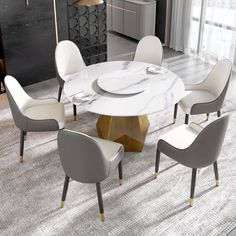 a dining table with chairs around it and a marble top in front of a large window