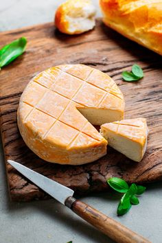 a piece of cheese on a wooden cutting board