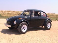 an old beetle car is parked in the desert