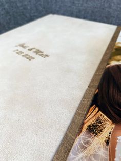 the back of a bride's wedding dress is shown in front of an open photo album