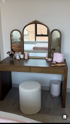 a vanity table with a mirror and stool