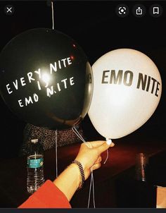 someone holding two balloons that say every nite emo nite