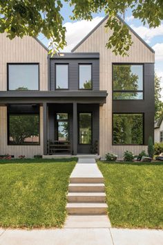 a modern house with stairs leading up to the front door