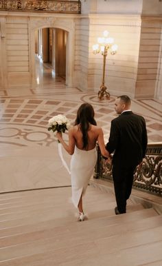 the bride and groom are walking down the stairs