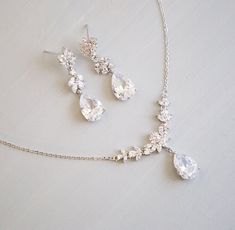 a necklace and earring set is shown on a white surface with a silver chain