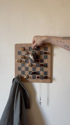 a person is playing chess on a wooden board with other items hanging from the wall