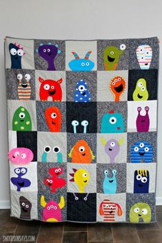 a quilt made to look like monsters on a wall