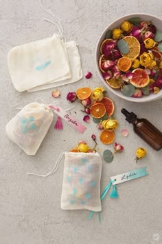 an assortment of citrus fruits and essential oils in small pouches next to a bowl of dried oranges