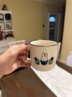 a hand holding a coffee cup with a bunny on it