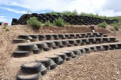 several rows of tires stacked on top of each other in front of a pile of dirt