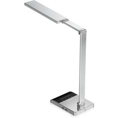 a desk lamp that is on top of a white surface and has a remote control in front of it