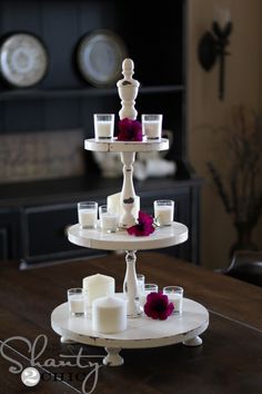 three tiered cake stand with candles and flowers