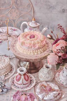 a table topped with lots of pink and white cakes