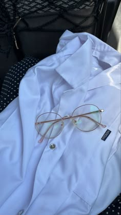 a pair of glasses sitting on top of a white shirt