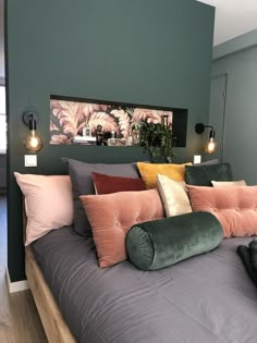 a bed that has some pillows on top of it in a room with green walls