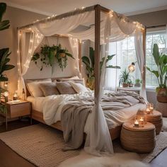 a bed with white sheets and lights on the headboard is surrounded by potted plants