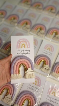 a person holding up some cards with rainbows on them in front of other greeting cards