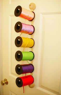 several spools of thread are hanging on the door