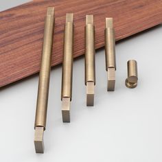 five brass door handles on a wooden board