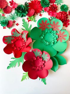 paper flowers and pine cones on a white surface