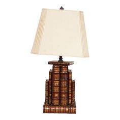 a lamp made out of books with a white shade on the top and bottom part