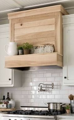 a white stove top oven sitting inside of a kitchen next to a wooden shelf above it