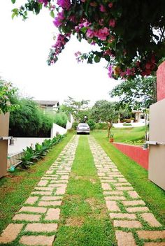 a car is parked on the side of a road in front of a wall and grass