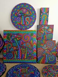 several colorful paintings and coasters on a table