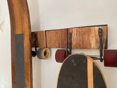 a skateboard is hanging on the wall next to two wooden racks with wheels attached