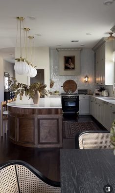 a kitchen with an island, stove and dining room table in it's center