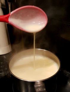 the sauce is being poured into the pot on the stove