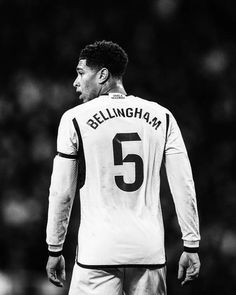 a black and white photo of a soccer player with the number five on his jersey