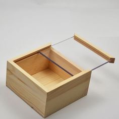 an empty wooden box sitting on top of a white table