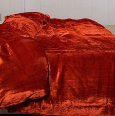 the bed is made up with an orange comforter