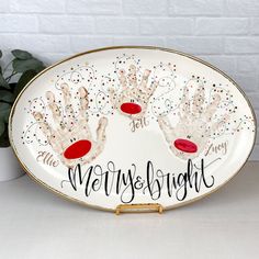 a plate with two handprinted hands on it and the words merry and bright