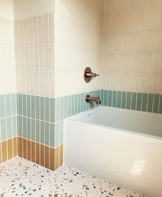 a bath tub sitting under a faucet in a bathroom