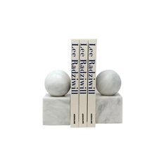 two white marble bookends sitting on top of each other next to each other