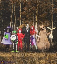 a group of people in halloween costumes standing next to each other near trees and bushes