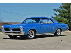 a blue muscle car parked in a parking lot