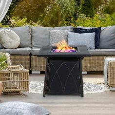 a fire pit sitting on top of a wooden floor next to a couch and table