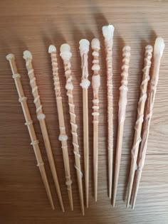 several different types of toothbrushes lined up on a wooden table with white tips