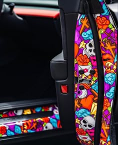 the interior of a car with colorful skulls and roses on it's seat belt