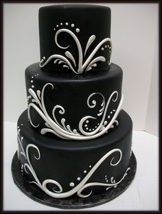 a three tiered black and white cake with swirls on it's sides