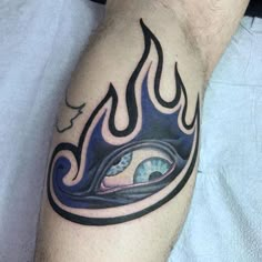 a man's arm with an eye and flames tattoo design on the side of his leg