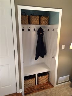 a coat rack with baskets and coats hanging from it's hooks on the wall