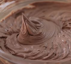 a bowl filled with chocolate frosting sitting on top of a table