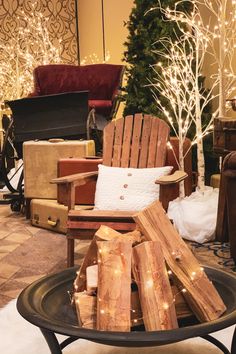 a pile of logs sitting on top of a black table next to a christmas tree